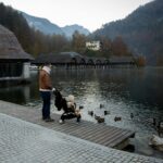 Šeima su vaiku oro uoste prieš kelionę rudens atostogų metu, tikrinant dokumentus ir kelionės draudimą.