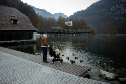 Šeima su vaiku oro uoste prieš kelionę rudens atostogų metu, tikrinant dokumentus ir kelionės draudimą.